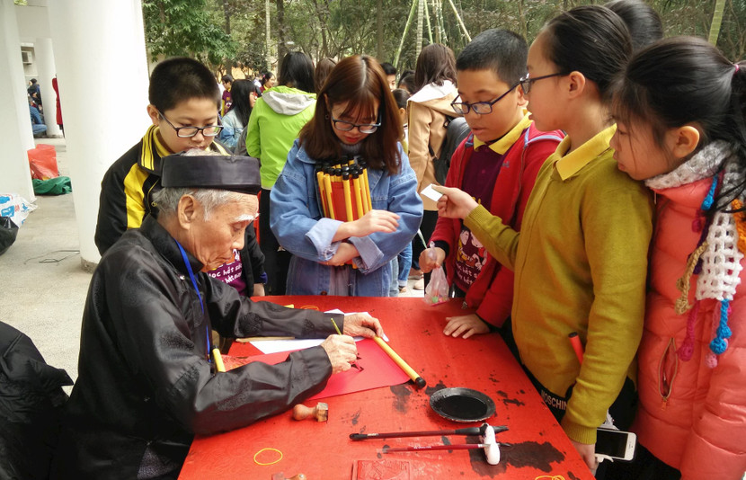 Du khách trải nghiệm hoạt động viết thư pháp ngày Xuân.