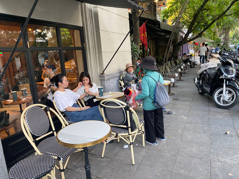 Cô gái ngồi uống cà phê dù đã từ chối nhưng người bán hàng rong vẫn cố gắng nài nỉ bằng được Cô gái ngồi uống cà phê dù đã từ chối nhưng người bán hàng rong vẫn cố gắng nài nỉ bằng được