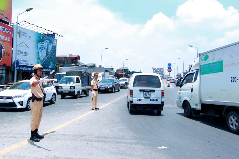 Dưới ánh nắng gay gắt cùng với nhiệt độ mặt đường bốc lên tại Hà Nội, lực lượng Cảnh sát giao thông vẫn phải căng mình bám trụ ở các nút giao trọng điểm phân luồng (Hình ảnh ghi nhận các chiến sỹ Đội CSGT số 1, CATP Hà Nội phân luồng tại nút giao cầu Chương Dương)