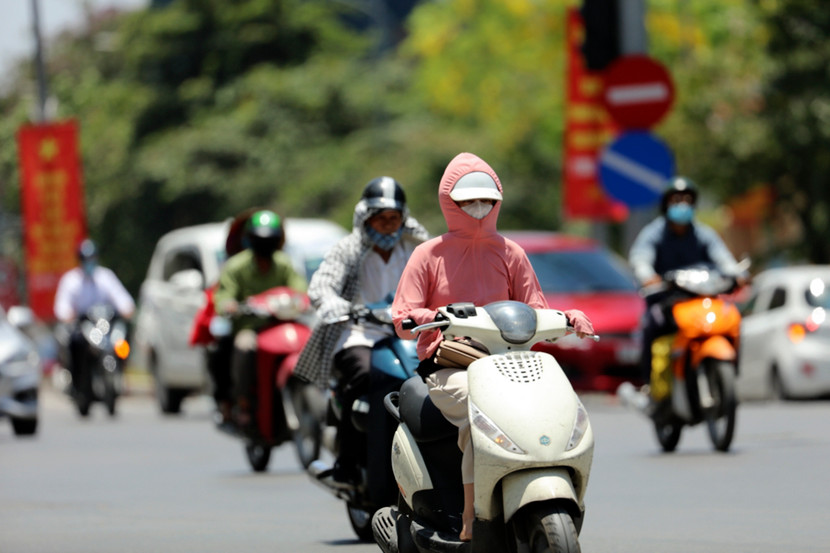 Dưới ánh nắng gay gắt, kèm nhiệt độ cao, người dân ở Hà Nội phải mặc đồ chống nắng trùm kín người khi tham gia giao thông