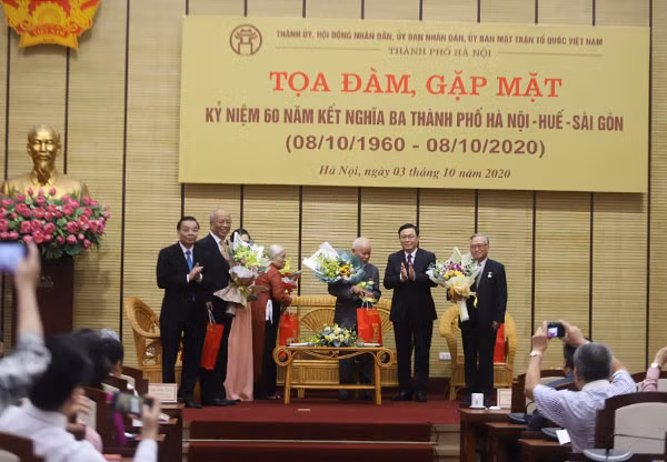 Bí thư Thành ủy Hà Nội Vương Đình Huệ và Chủ tịch UBND thành phố Hà Nội Chu Ngọc Anh tặng hoa các nhân chứng lịch sử