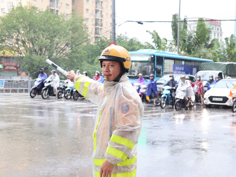 Dưới cơn mưa tầm tã, lực lượng Cảnh sát giao thông vẫn nghiêm chỉnh làm nhiệm vụ
