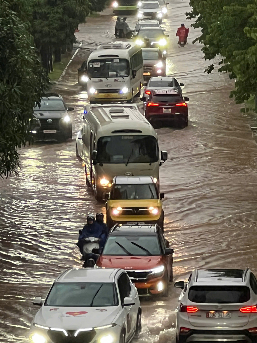 Người dân thận trọng di chuyển qua tuyến phố ngập úng