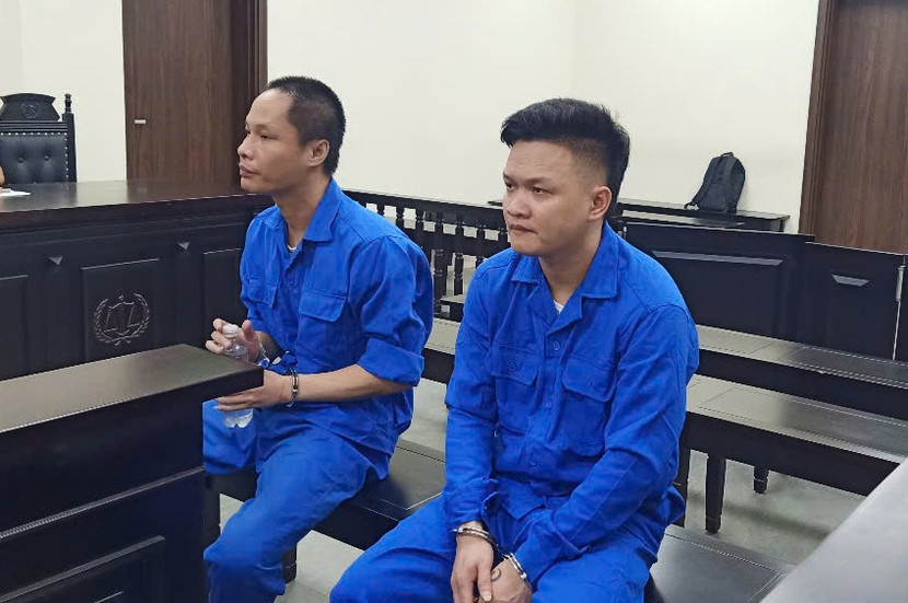 Bị cáo Hoàng Mai Đức (bên bải) bị đưa ra xét xử tại tòa