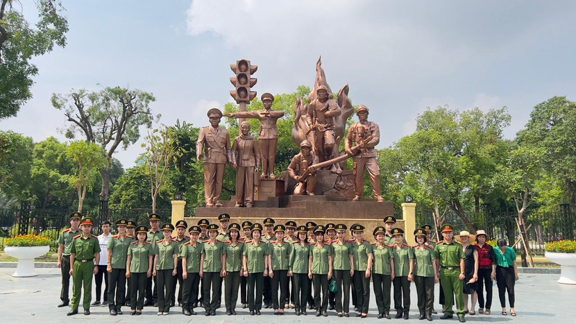 Các chiến sĩ Cục Công tác Đảng và công tác chính trị chụp ảnh lưu niệm tại tượng đài "Công an nhân dân vì dân phục vụ"