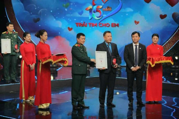 Đại tá Tào Đức Thắng– Chủ tịch, Tổng Giám đốc Tập đoàn Công nghiệp Viễn thông Quân đội Viettel và ông Đỗ Thanh Hải – Phó Tổng Giám đốc Đài THVN trao kỷ niệm chương cho đại diện các nhà hảo tâm, các nhà tài trợ luôn đóng góp cho Trái tim cho em.