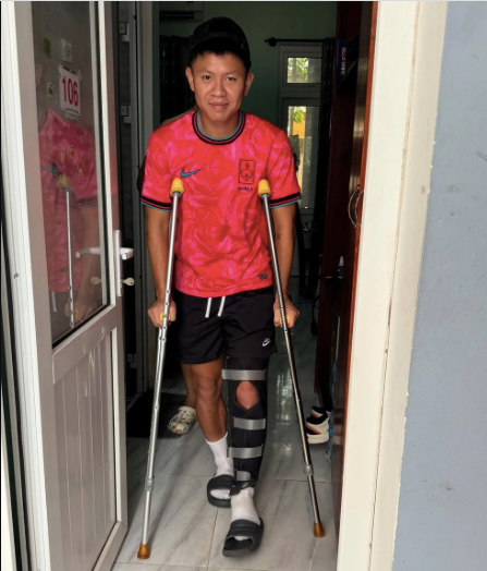 Hình ảnh Vũ Tiến Long chống nạng di chuyển trước khi được phẫu thuật