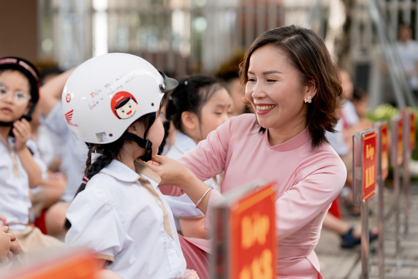 Giáo viên hướng dẫn các em đội mũ bảo hiểm đúng cách Giáo viên hướng dẫn các em đội mũ bảo hiểm đúng cách