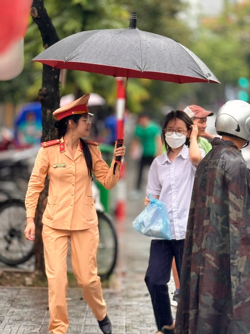 Chiến sĩ Cảnh sát giao thông che ô cho thí sinh vào điểm thi an toàn