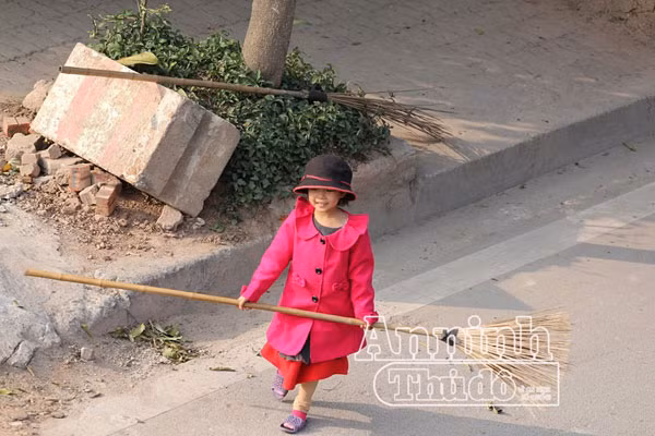 Xúc động hình ảnh em bé đi quét rác cùng mẹ trong ngày Tết ảnh 2