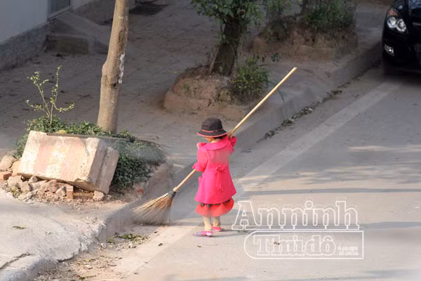 Xúc động hình ảnh em bé đi quét rác cùng mẹ trong ngày Tết ảnh 3