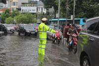 Cảnh sát giao thông dầm mình trong mưa lớn, đường ngập để phân luồng chống ùn tắc