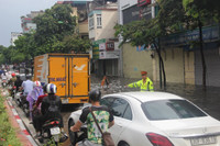 Cảnh sát giao thông dầm mình trong mưa lớn, đường ngập để phân luồng chống ùn tắc