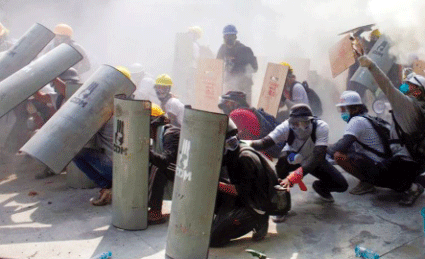 Những người biểu tình chống đỡ khi đụng độ với cảnh sát ở Yangon