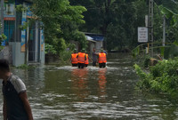 Dùng thuyền tiếp tế thực phẩm cho người dân bị cô lập do mưa bão gây ngập úng ở giáo xứ Đồng Chiêm