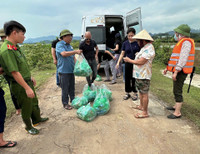 Dùng thuyền tiếp tế thực phẩm cho người dân bị cô lập do mưa bão gây ngập úng ở giáo xứ Đồng Chiêm
