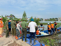 Dùng thuyền tiếp tế thực phẩm cho người dân bị cô lập do mưa bão gây ngập úng ở giáo xứ Đồng Chiêm