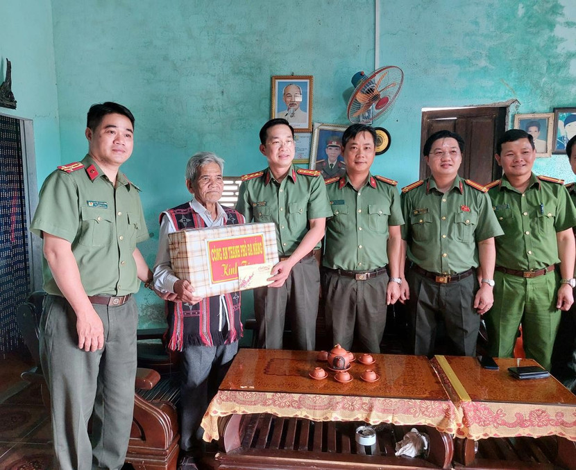 Thay mặt Đảng ủy, Ban Giám đốc Công an TP Đà Nẵng, Đại tá Nguyễn Đajai Đồng tặng quà đầu Xuân mới cho ông Lê Văn Nghĩa và già làng Đinh Văn Trí