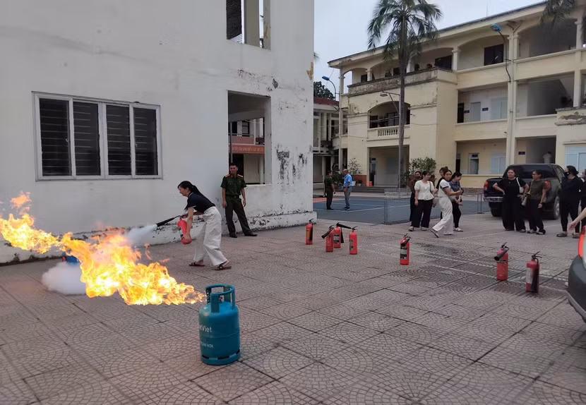 Học viên thực hành sử dụng bình chữa cháy.