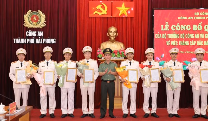 Thiếu tướng Bùi Quang Bình, Ủy viên BTV Thành ủy, Bí thư Đảng ủy, Giám đốc CATP trao Quyết định và tặng hoa chúc mừng các đồng chí Trưởng các phòng nghiệp vụ CATP được thăng cấp bậc hàm Đại tá