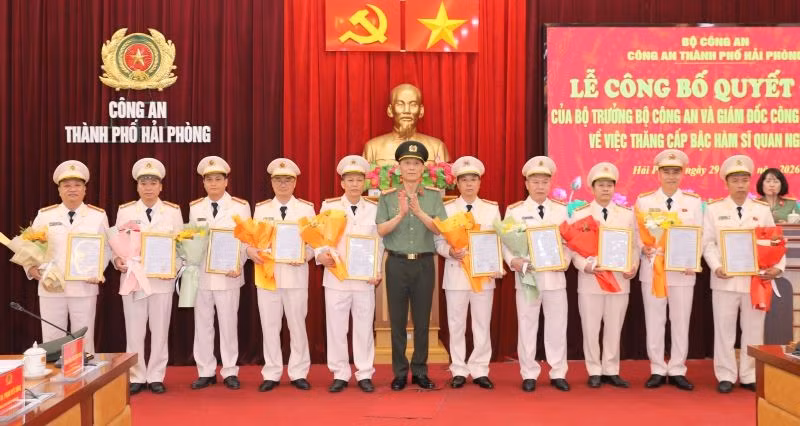 Đại tá Phạm Viết Dũng, Phó Bí thư Đảng ủy, Phó Giám đốc CATP trao Quyết định và tặng hoa chúc mừng các đồng chí Trưởng Công an cấp xã được thăng cấp bậc hàm Thượng tá.