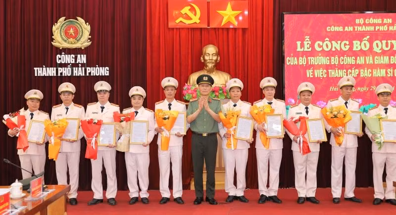 Đại tá Phạm Viết Dũng, Phó Bí thư Đảng ủy, Phó Giám đốc CATP trao Quyết định và tặng hoa chúc mừng các đồng chí Trưởng Công an cấp xã được thăng cấp bậc hàm Thượng tá.