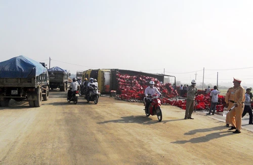 Xe tải bị lật, hàng trăm két bia tràn xuống đường