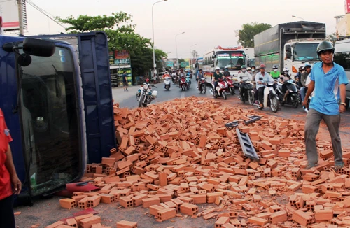 Xe tải bất ngờ “trút” gạch xuống giữa QL1A