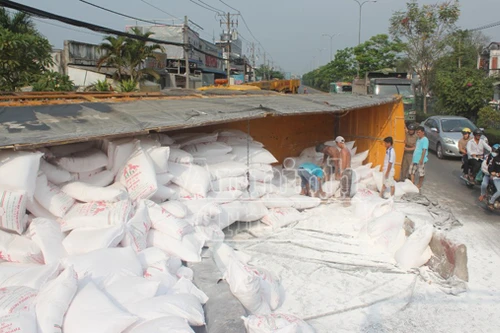 Xe tải lật ngang quốc lộ 22, hàng trăm bao bột mỳ rơi "trắng" đường