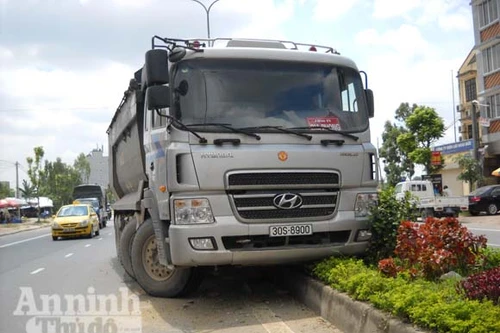 Xe tải “hôn” vệ đường