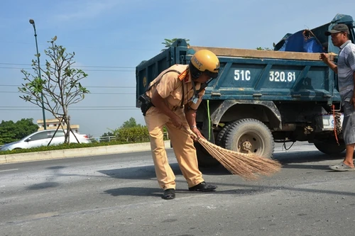 CSGT quét dọn đá rơi vương vãi khắp mặt đường giữa trưa