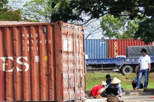 Thùng container chở gạo văng xuống đường, dân giúp tài xế giữ hiện trường