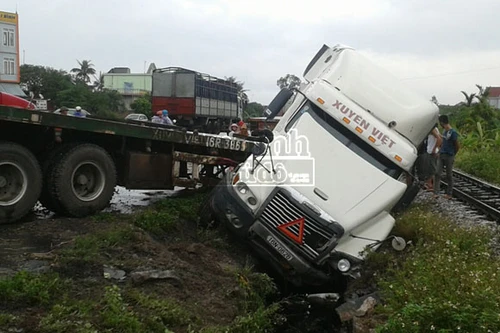 Xe tải chở cát "húc" xe container xuống cống thoát nước bên đường
