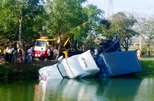 Container lao xuống ao, 2 người thoát chết 