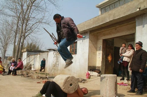 Đặt đá lên bụng cho người khác đứng nhảy dây