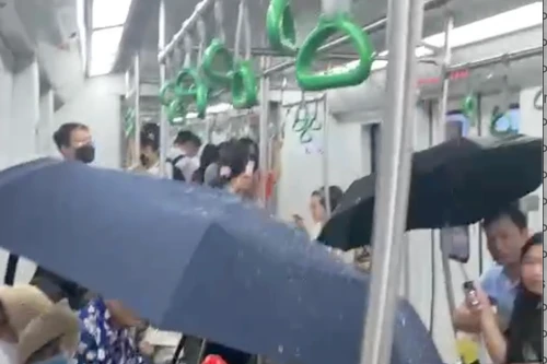 Người dân che ô trên tàu metro Cát Linh- Hà Đông vì nước chảy tong tong