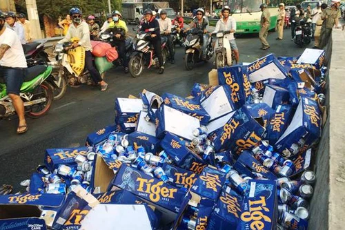 Người dân giúp tài xế thu dọn hàng trăm thùng bia đổ xuống đường