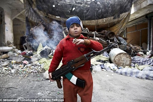 Sốc với hình ảnh chiến binh 7 tuổi khoác AK-47, phì phèo thuốc lá