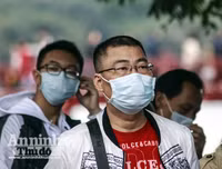 [ẢNH] Đề phòng mắc nCoV, du khách không rời khẩu trang y tế khi du xuân