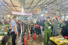 Cán bộ phòng cháy hướng dẫn tiểu thương chữa cháy hiệu quả tại chợ