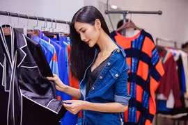 Hoàng Thuỳ kéo vai áo trễ nải khi đi thử đồ