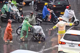 Phóng sự ảnh: Khoảnh khắc sưởi ấm lòng người dưới mưa lớn trong giờ tan tầm ở Hà Nội