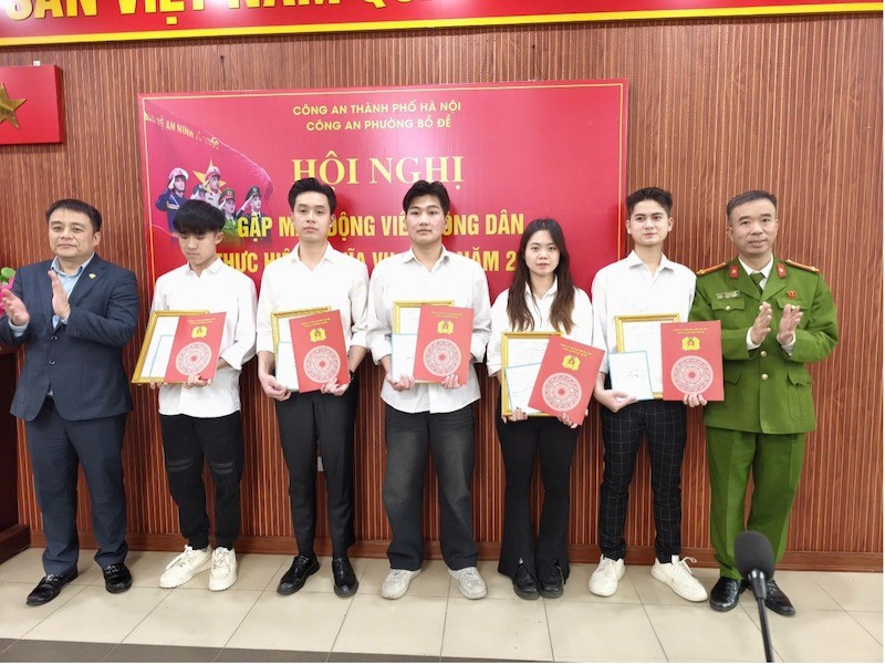 Chủ tịch Hội đồng nghĩa vụ quân sự cùng các đồng chí trong Đảng uỷ, Ban chỉ huy Công an phường Bồ Đề (Hà Nội) tặng quà cho 5 công dân tham gia nhập ngũ, trong đó có nữ công dân tham gia nghĩa vụ CAND.