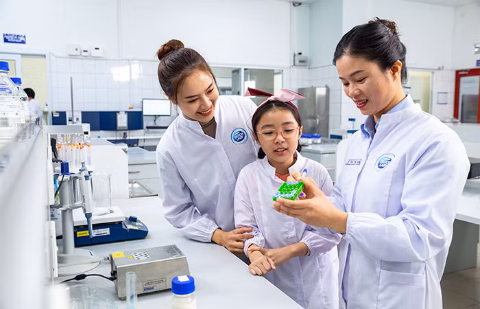 Nhân viên nữ của Friesland Campina Việt Nam luôn được tạo động lực phát triển trong công việc và bản thân. Trong ảnh, chị Lê Thị Thoan (cầm bút), nhân viên phòng Quản lý chất lượng luôn có niềm đam mê với nghề hơn 10 năm