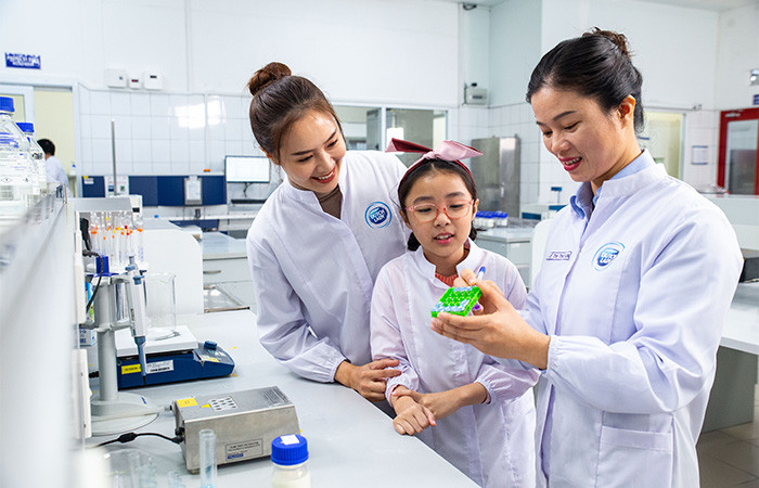 Nhân viên nữ của Friesland Campina Việt Nam luôn được tạo động lực phát triển trong công việc và bản thân. Trong ảnh, chị Lê Thị Thoan (cầm bút), nhân viên phòng Quản lý chất lượng luôn có niềm đam mê với nghề hơn 10 năm