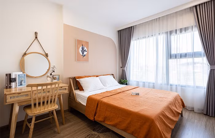 Phòng ngủ tận dụng ánh sáng tự nhiên từ khung cửa sổ lớn và sắc cam mang đến cảm giác dễ chịu, thư thái. Giường, tủ sử dụng vật liệu tre tạo nên nét mộc mạc, giản dị và ấm áp.