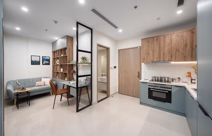 Khu vực cộng thêm tại căn hộ 1 phòng ngủ ở Vinhomes Smart City được tận dụng làm không gian làm việc với kệ trang trí và ghế sofa nghỉ ngơi, đọc sách