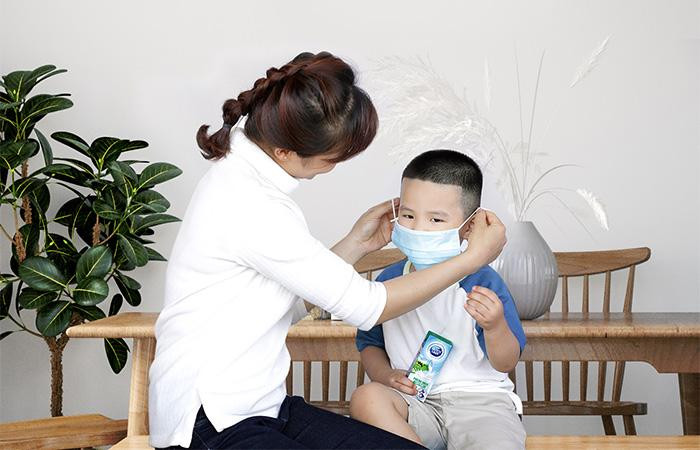 Cha mẹ hãy luôn đeo khẩu trang đúng cách cho con trước khi đến nơi công cộng