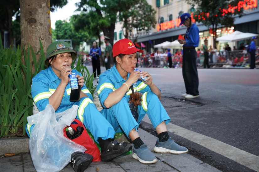 Phút nghỉ ngơi và tiếp thêm chút năng lượng bằng sữa tươi Vinamilk của các chị góp phần quan trọng để đại lễ diễn ra với những tuyến đường sạch sẽ, ngăn nắp. (Ảnh: Vi Nam)