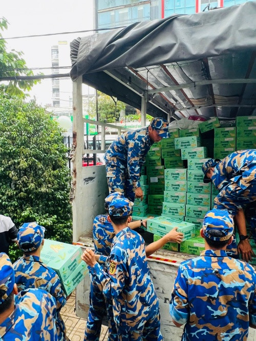 Các chiến sĩ Trung tâm Huấn luyện Vùng 4 Hải quân đang chuyền nhau các sản phẩm dinh dưỡng Vinamilk, sẵn sàng vận chuyển đến tận tay bà con vùng lũ - Ảnh: Vi Nam